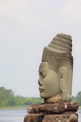 Fototapeta premium Stone statue Deva at the south gate of Angkor Thom, Angkor Wat. Overlooking the Moat