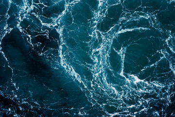 Rapid sea with waves and foam while sailing ship.