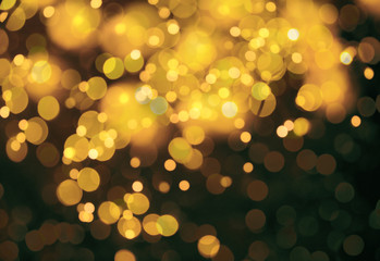 Blurred view of gold lights on dark background, bokeh effect