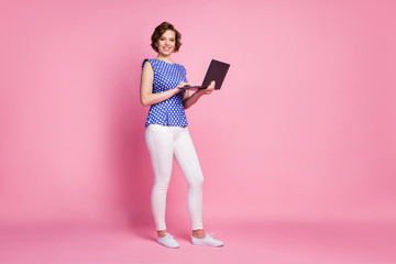 Full length body size view of her she nice-looking attractive lovely cheerful cheery wavy-haired girl holding in hands laptop preparing finance report review isolated on pink pastel color background