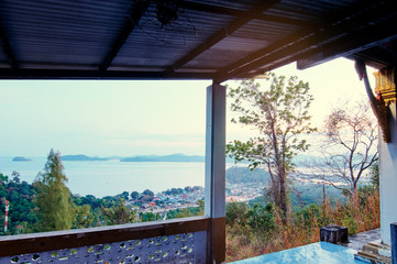 Fototapeta na wymiar Beautiful view from a hilltop capturing coastal town and it's calming bay. Phuket, Thailand.