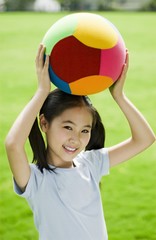 Girl holding ball on her head