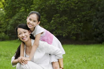 Mother carrying daughter on her back