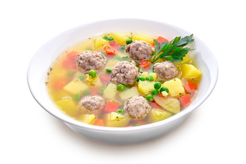 Meatballs with green peas in the potato soup