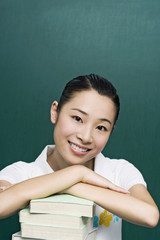 Young woman posing with a stack of books