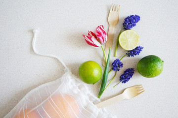 
fabric bag for storing products with different citrus, wooden forks and flowers . Zero waste concept