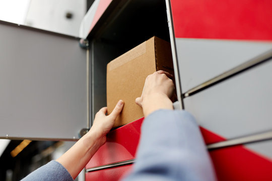 mail delivery and post service concept - woman putting box to automated parcel machine