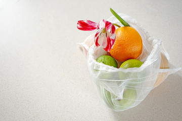
eco bag  with different citrus and flowers on a light background. The concept of zero waste and no plastic