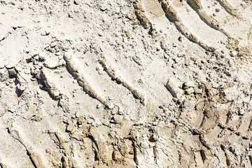 ATV tracks in the sand in harsh sunlight