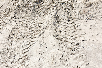 ATV tracks in the sand in harsh sunlight