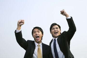 Two businessmen cheering