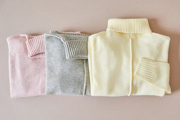 top view of pink, beige and grey knitted soft sweaters