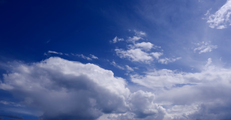 Naklejka na ściany i meble Beautiful mesmerizing clouds in a blue sky on a bright Sunny day
