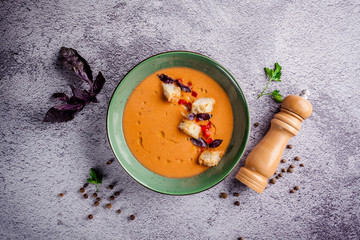 Spanish cuisine. Cold summer tomato soup gazpacho with croutons and basil.