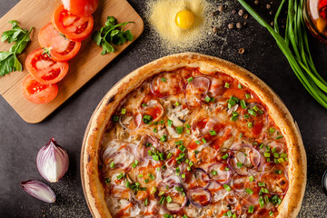 Italian Cuisine. Thin pizza with bacon, red onion, green onion and mushrooms in tomato sauce. Background image. copy space