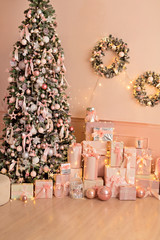 Beautiful festive decorated pink room with a Christmas tree with gifts under it.