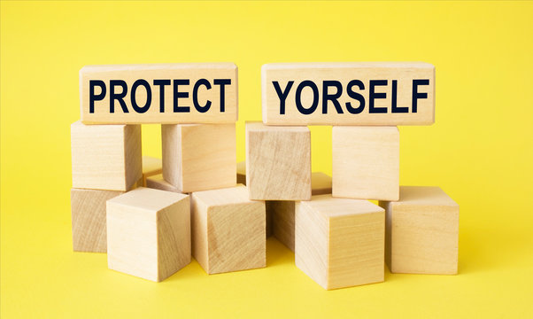 Medical concept ,on wooden blocks the text protect yourself on a yellow background