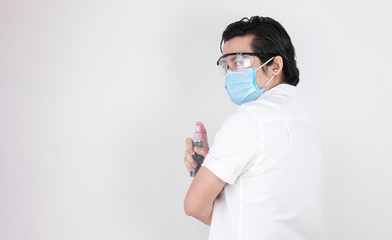 Asian men standing back on white background wearing masks. Dustproof Goggles and Alcohol Bottle Holders, Covid-19 Concept