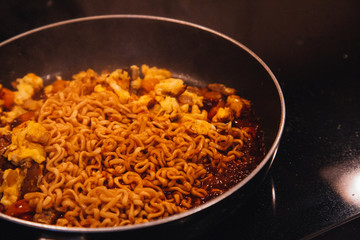 frying pan with vegetables and noodles