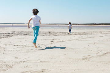 2 boys in jeans run along the coast from the list of Sunny Summer Day