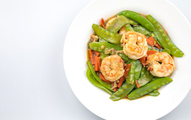 Stir-fried peas, put shrimp in a white plate on a white background.