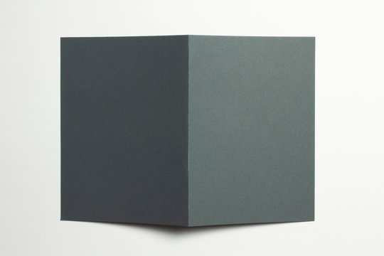Blank black paper bi-fold card brochure front cover isolated on white as template for design presentation, greeting cards, event promotion etc.