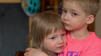brother and sister together. brother hugs his sister at home. family and love