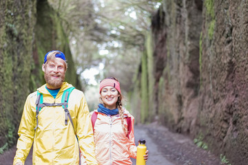 Young couple doing forest excursion - Happy people having fun discovering nature woods - Youth travel and love relationship lifestyle concept