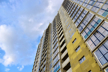 Mineral wool insulation of the facade building on construction site. Thermal protection of house. Installation double-glazed windows with frames. Modern residential buildings architecture background