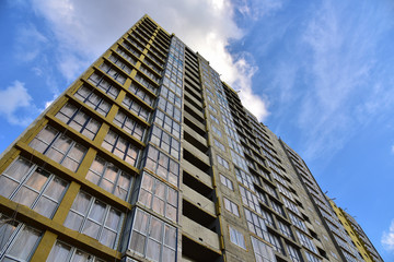 Fototapeta premium Mineral wool insulation of the facade building on construction site. Thermal protection of house. Installation double-glazed windows with frames. Modern residential building on blue sky background