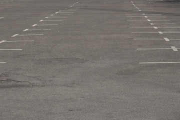 Old, dirty and fading white markings in a empty parking lot