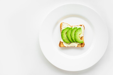 Avocado sandwich with garlic white sauce on a white plate. White background