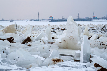 Broken ice on the river. The frozen river against the backdrop of the city. The river in the winter