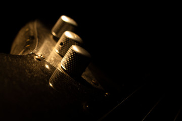 Bass guitar closeup on volume knob in music studio shot at golden hour