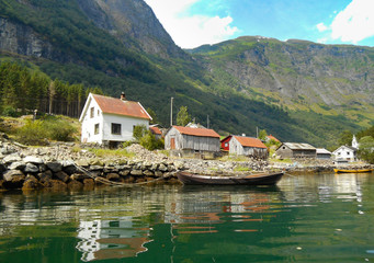 Fototapeta na wymiar Houses on the edge of Norwegian fjord with reflections