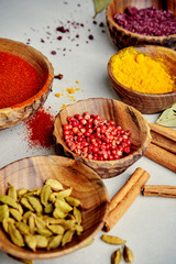 Colorful spices in wood bowls on grey background with copy space. Nature Seasoning Pepper, turmeric, paprika, rosemary, chilly, cardamom, cinnamon, anise, cloves. ingredients.