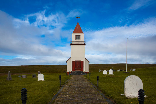 
Landscape on Grimsey Island in northern Iceland beyond the Arctic Circle. A white church with a red roof is visible, surrounded by a cemetery with white tombs