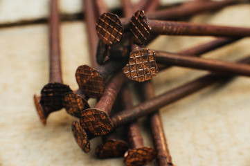 Scrap copper, old copper dirty oxidized nails. Against the background of an untreated wooden board. Close-up. Macro.