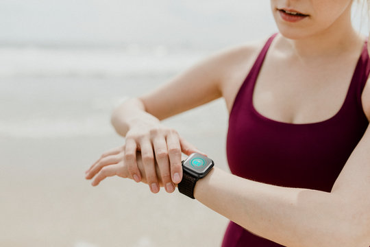 Active woman using a smartwatch - Powered by Adobe