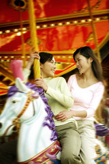 Women on carousel at amusement park