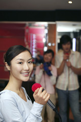 Woman smiling at the camera while holding a microphone