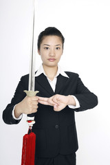 Businesswoman practising martial arts with a sword