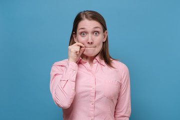 European woman showing zip gesture as if shutting mouth on key. © RealPeopleStudio