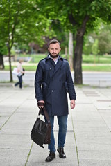 young businessman on street wearing coat 