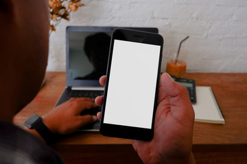 The cropped shot view of The asian woman works on the wood desk with the mobile phone,note book,and claculator with blank copy space screen for  information content or text message.for work from home.