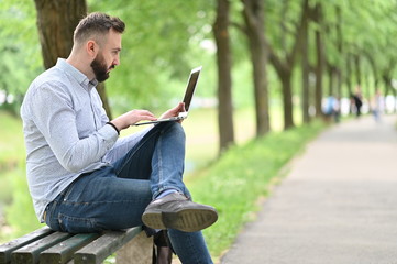 Obraz premium young man using laptop in park 