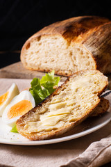Healthy meal food concept homemade organic artisan sourdough bread and boiled egg in white plate with copy space