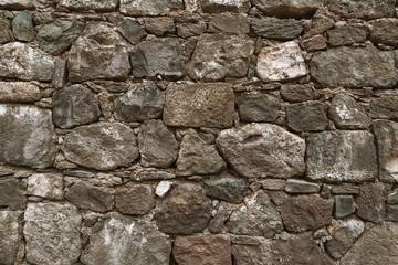 Textured background of cobblestones. Background of shabby wall of old building with various shape stones