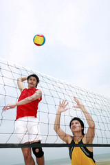 Men playing volleyball on the beach