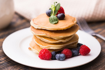 Homemade american pancakes with fresh blueberry and raspberries. Healthy morning breakfast. Rustic style